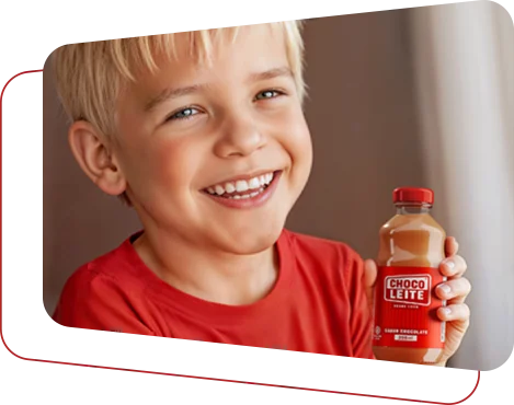 Menino sorrindo com uma garrafa de Choco Leite